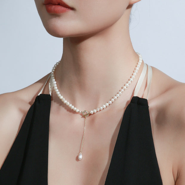 14k Gold Freshwater Pearl Necklace with genuine pearls in classic white or alluring purple, featuring an adjustable flat gold chain for versatile wear.