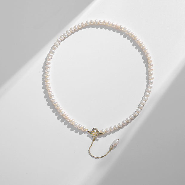 14k Gold Freshwater Pearl Necklace with genuine pearls in classic white or alluring purple, featuring an adjustable flat gold chain for versatile wear.